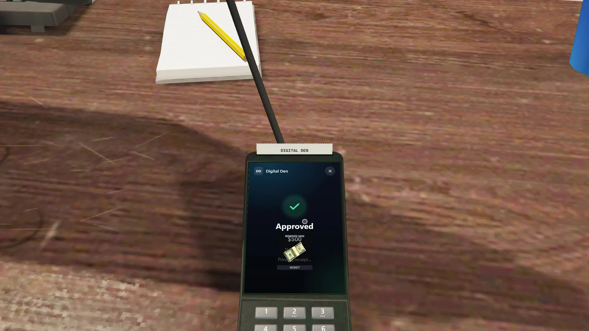 Card terminal on a shop counter showing an approved $500 payment